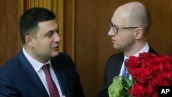 FILE - Prime Minister Arseniy Yatsenyuk, right, and parliament speaker Volodymyr Groysman are seen during the opening first session of the Ukrainian parliament in Kyiv, Nov. 27, 2014. Ukraine is looking to create a new coalition government this week following Yatsenyuk's resignation.