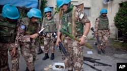 FILE - A U.N. peacekeeper collect weapons from the army headquarters of Ivory Coast's strongman Laurent Gbagbo in Abidjan. 