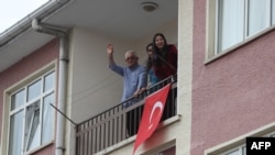 Residents wave from their balcony as they attend a concert by artists from the Kecioren municipality conservatory performing from the roof of a bus on April 2, 2020, in Ankara, as the country is under lockdown to stop the spread of the Covid-19…