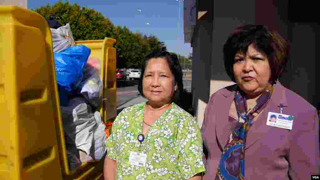 两名菲律宾裔护士站在捐赠的衣物前（美国之音国符拍摄）