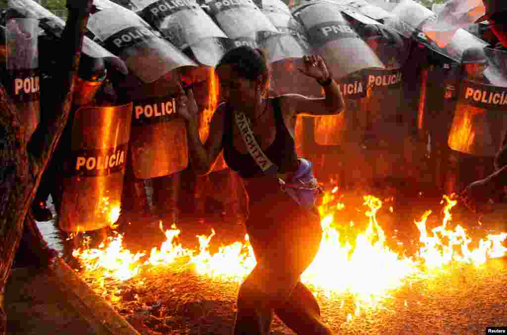 A demonstrator reacts when Molotov cocktails hit the ground in front of security forces during protests against election results after Venezuela&#39;s President Nicolas Maduro and his opposition rival Edmundo Gonzalez claimed victory in the presidential election, in Puerto La Cruz, July 29, 2024.&nbsp;