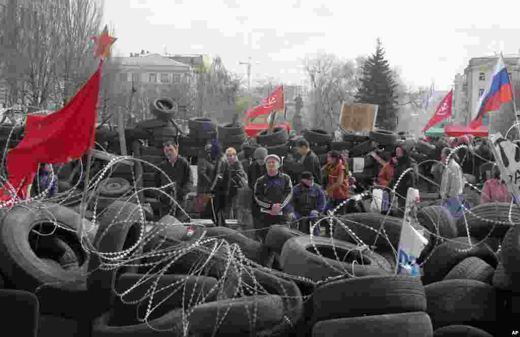People stand at a barricade at the regional administration building that Moscow loyalists had seized earlier in Donetsk, Ukraine, April 15, 2014.