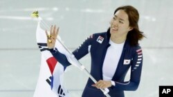 러시아 소치 동계올림픽에 출전한 한국 이상화 선수가 11일 여자 스피드스케이팅 500m 경기에서 금메달이 확정된 후 태극기를 들고 기뻐하고 있다.