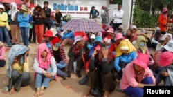 Workers gather during their strike in front of a factory owned by Sabrina (Cambodia) Garment Manufacturing in Kampong Speu province, west of the capital, Phnom Penh, May 30, 2013. 