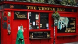 A man dressed as St Patrick walks past a closed Temple bar in Dublin city centre, Monday, March, 16, 2020.