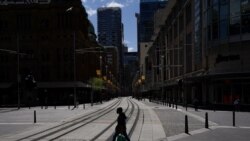 A pedestrian wearing a protective face mask crosses tram lines in the city center during a lockdown to curb the spread of COVID-19 in Sydney, Australia, 24, 2021.