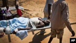 FILE - A man with a gunshot wound in his leg is carried by stretcher inside the Juba Military Hospital in Juba, South Sudan, Dec. 28, 2013. 