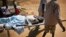 FILE - A man with a gunshot wound in his leg is carried by stretcher inside the Juba Military Hospital in Juba, South Sudan, Dec. 28, 2013. 