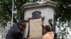 A banner is taped over the inscription on the pedestal of the toppled statue of Edward Colston in Bristol, England, June 8, 2020.
