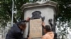 A banner is taped over the inscription on the pedestal of the toppled statue of Edward Colston in Bristol, England, June 8, 2020.