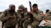 FILE - Kurdish People's Protection Units (YPG) fighters carry their weapons while riding on the back of a pick-up truck in Qamishli, Syria, March 11, 2016. 