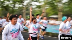Runners flash the three-finger salute of resistance to authority as they attend the "Run Against Dictatorship" event in Bangkok, Jan. 12, 2020.