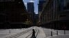 A pedestrian wearing a protective face mask crosses tram lines in the city center during a lockdown to curb the spread of COVID-19 in Sydney, Australia, 24, 2021.