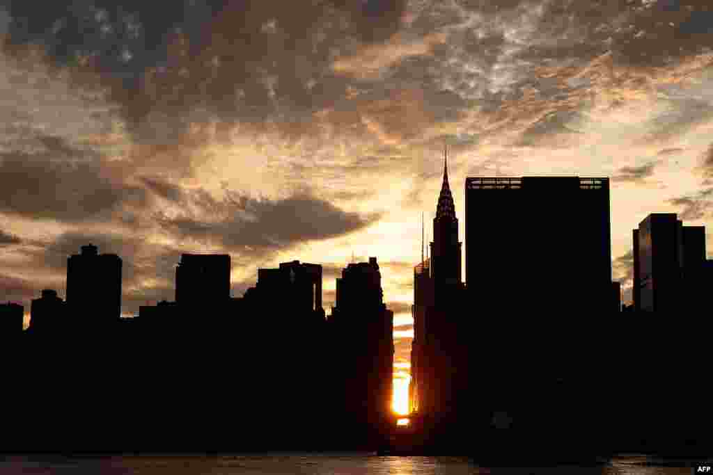 A view of the 'Manhattanhenge' sunset — when the setting sun aligns with the city's street grid — from Hunters Point South Park, in the Queens borough of New York City, July 11, 2016.