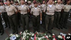 Guardias nacionales bolivarianas ante ofrendas florales por los muertos en los disturbios venezolanos.