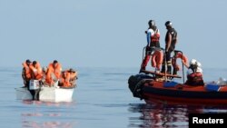 Des migrants à bord d’un bateau en Mer Méditerranée, au large des côtes libyennes, le 12 août 2018.