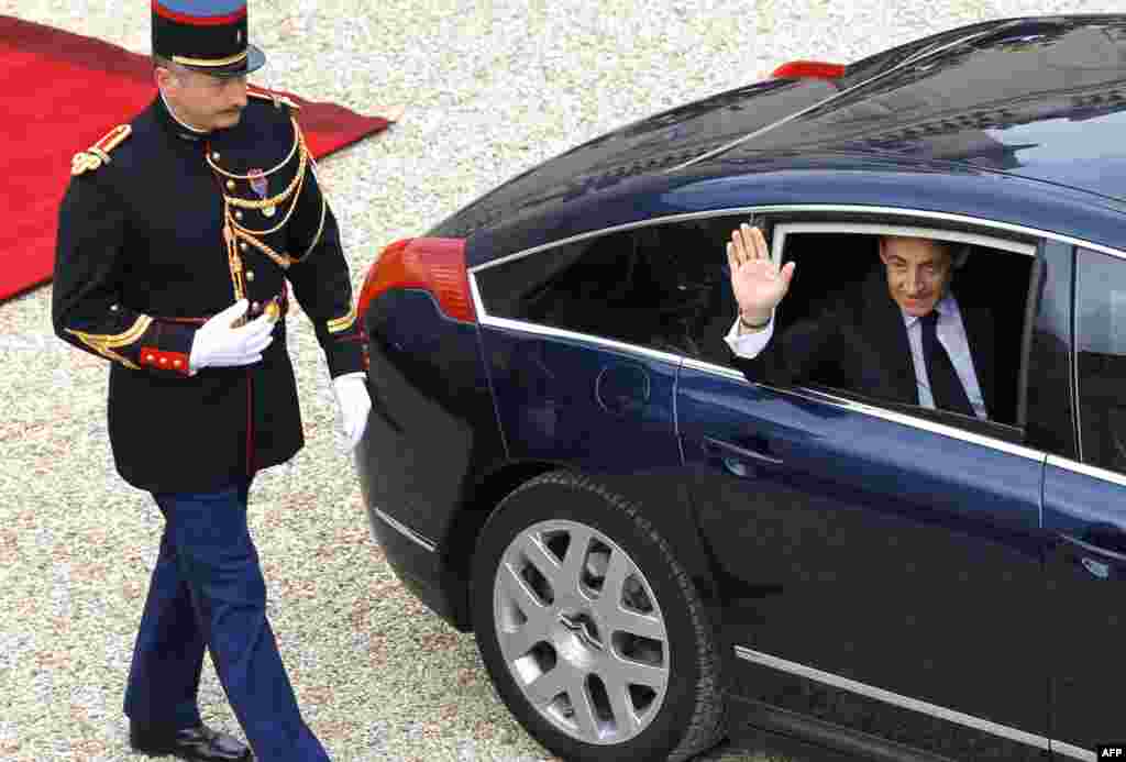 Outgoing President Nicolas Sarkozy waves as he leaves the Elysee Palace after the handover ceremony. (AP)