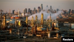 FILE - The Philadelphia Energy Solutions oil refinery is seen at sunset in front of the Philadelphia skyline in Pennsylvania, March 24, 2014.