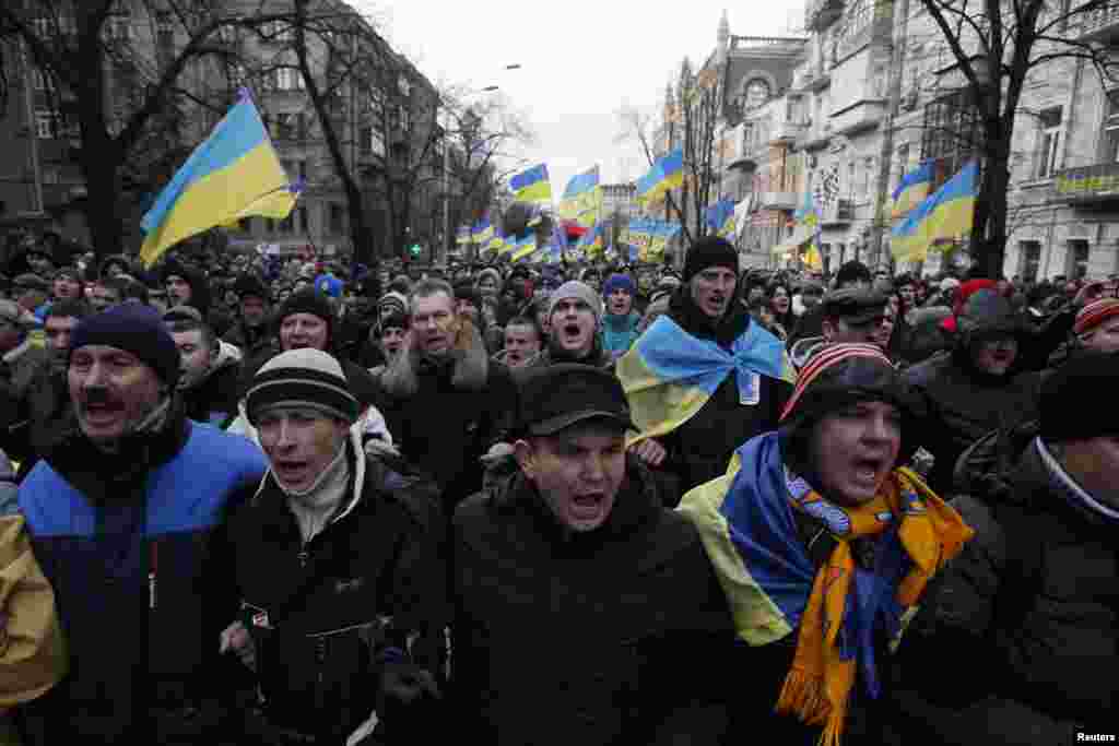 Protesters wave flags and shout slogans during a demonstration in support of EU integration in Kyiv, Dec. 3, 2013.