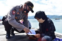 Iptu Siswanto saat sedang mengajar anak-anak di Pulau Lutungan, Kecamatan Baolan, Kabupaten Tolitoli, Sulawesi Tengah. Kamis, 6 Agustus 2020. Foto : Humas Polres Tolitoli