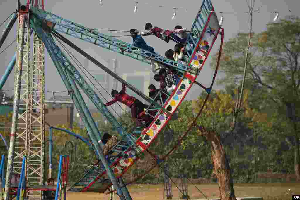 Children ride on a swing on Christmas Day in Islamabad, Pakistan.