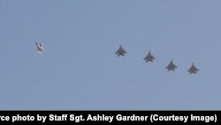 지난 6월 미 공군 소속 F-22 전투기 편대가 카타르 알우데이드 공군기지 상공을 비행하고 있다.