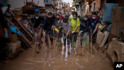 Volunteers and residents clean the mud from the streets in an area affected by floods in Paiporta, Valencia, Spain, Nov. 5, 2024.