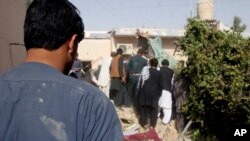 Afghans inspect the site of a suicide attack in Lashkar Gah, the capital of Helmand Province, Afghanistan, Tuesday, Oct. 9, 2018. A suicide bomber on Tuesday struck the home of a candidate in Afghanistan's parliamentary elections.