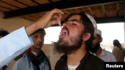 A man, who fled the military offensive against the Pakistani militants in North Waziristan, receives polio vaccination drops upon his arrival in Bannu in Khyber-Pakhtunkhwa province, Pakistan, June 22, 2014.