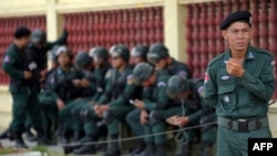 FILE - Cambodian police officers are posted outside a building in Phnom Penh, Aug. 22, 2018.