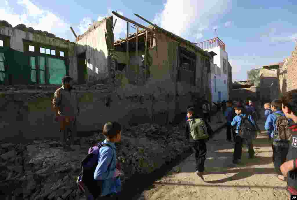 Afghan school boys look at a damaged house following a powerful earthquake that could be felt across South Asia, in Kabul, Oct. 26, 2015.