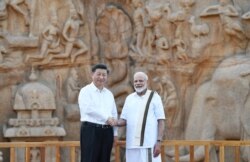 Perdana Menteri India Narendra Modi dan Presiden China Xi Jinping berjabat tangan saat mengunjungi monument Arjuna, 11 Oktober 2019.