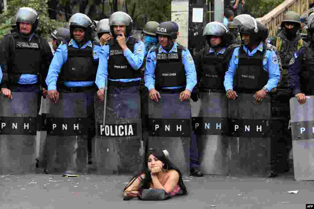 Salvador Nasralla, s supporter of the presidential candidate for the Honduran Opposition Alliance Against the Dictatorship, lies on the street in front of police officers during a demonstration against the contested re-election of of President Juan Orlando Hernandez, in Tegucigalpa, Jan. 21, 2018.