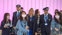 Para penumpang dan staf maskapai penerbangan mengenakan masker di bandara Los Angeles, California.