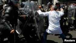 La policía reprime a un médico durante una marcha antigubernamental en Caracas.
