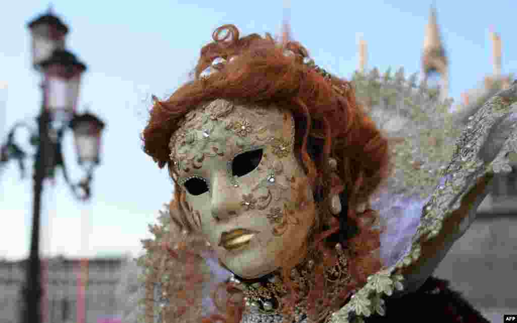 A masked reveler is een in Venice&#39;s Riva degli Schiavoni on the opening day of the Venice Carnival, Italy.