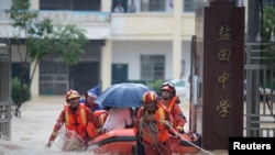 Rescue workers evacuate with an inflatable boat students stranded by floodwaters at a school, amid heavy rainfall in Duchang county, Jiangxi province, China July 8, 2020.
