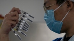 FILE - In this Thursday, Sept. 24, 2020 file photo, a worker inspects syringes of a vaccine for COVID-19 produced by Sinovac at its factory in Beijing. Sinovac and Sinopharm both rely on a traditional technology called an inactivated virus vaccine, based 