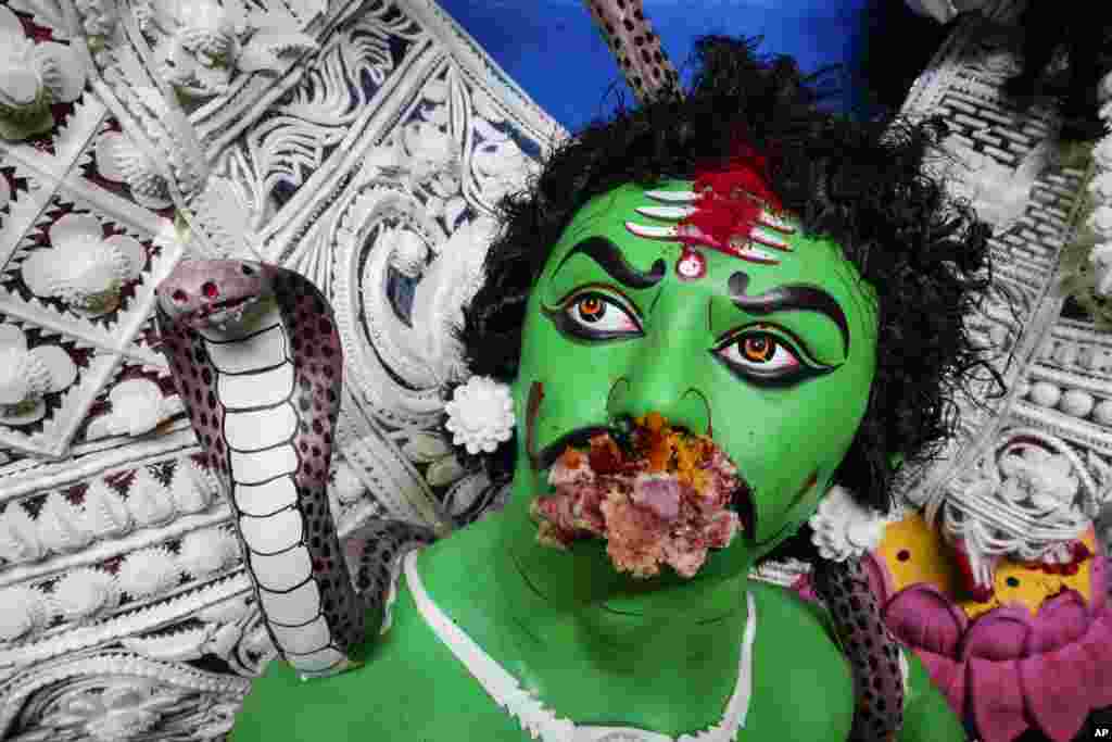 An idol of demon king, Mahisarura, a part of worship with Hindu goddess Durga, is seen with sweets fed by devotees before it is carried for immersion in the Hooghly River, in Kolkata, India.