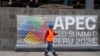 Un trabajador pasa junto a un cartel que anuncia la cumbre de Cooperación Económica Asia-Pacífico (APEC) en el exterior del Ministerio de Cultura en Lima, Perú, el martes 12 de noviembre de 2024. [Foto AP/Fernando Vergara]