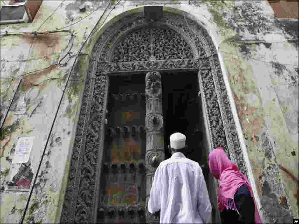 Muslim faithfuls enter a building in the historic centre of Stone Town in the Indian Ocean Island of Zanzibar