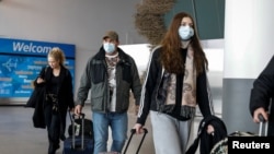 지난달 20일 미국 뉴욕 존 F. 케네디 공항에서 여행객들이 마스크를 착용하고 있다. 