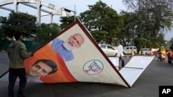 Municipal workers remove a hoarding displaying an image of Indian Prime Minister Narendra Modi in Lucknow, in the central Indian state of Uttar Pradesh, on March 16, 2024. India's six-week-long general elections will start on April 19,