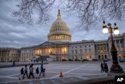 FILE - People walk by the U.S. Capitol in Washington, Jan. 21, 2018.