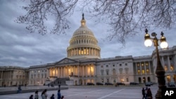 People walk by the U.S. Capitol in Washington, Jan. 21, 2018.