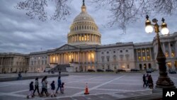 FILE - People walk by the U.S. Capitol in Washington, Jan. 21, 2018.