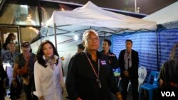 Pemimpin demonstrasi anti-pemerintah Suthep Thaugsuban (depan) bersama istrinya Srisakul Promphan (berbaju putih) tiba di monumen Demokrasi di Bangkok, Thailand (15/12). (AP/Manish Swarup)