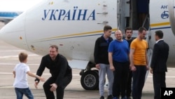 Ukraine's President Volodymyr Zelenskiy, right, greets Ukrainian prisoners upon their arrival at Boryspil airport, outside Kyiv, Ukraine, Sept. 7, 2019. 