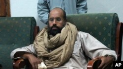 FILE - In this Nov. 19, 2011, file photo, Seif al-Islam is seen after his capture in the custody of revolutionary fighters in Zintan, a town south of the capital Tripoli, Libya. 