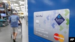 Seorang konsumen berjalan melalui iklan kartu kredit Sam's Club MasterCard di Bentonville, Arkansas, 4 Juni 2015.